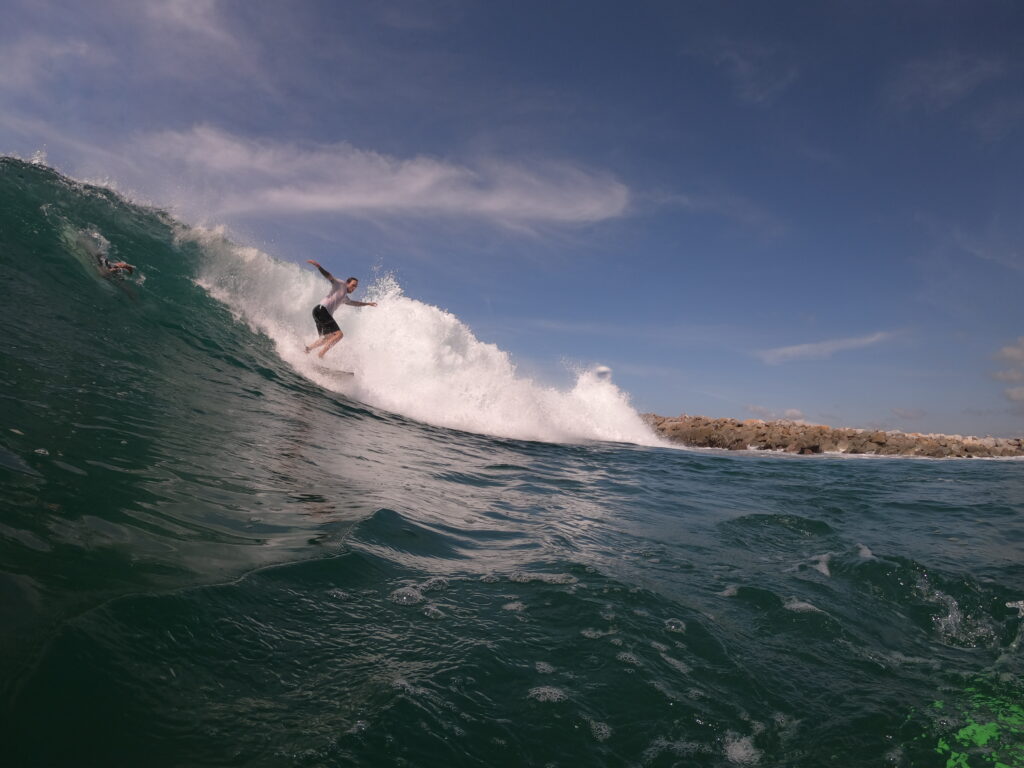 Surfer carving a powerful wave at Salina Cruz, Oaxaca, with the sun setting over the horizon Toro Surf trips Mexico Waves Thermal